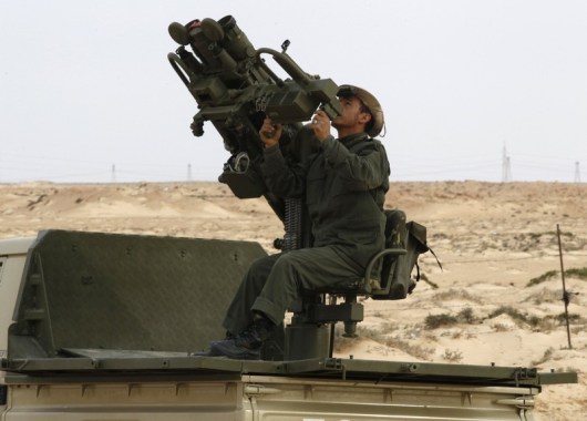 A Libyan government soldier monitors using anti-aircraft weapons at the west gate of town Ajdabiyah